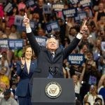 Tim Walz Story Is Starting to Unravel People cheering at a political rally, man raising arms.