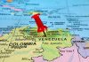 Venezuelan Pressure Escalates Under Trump Red pin on Venezuela, South America map.
