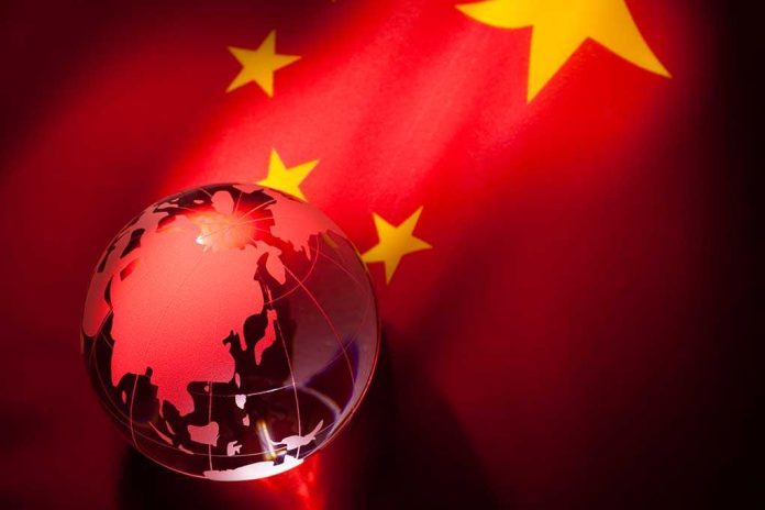 shutterstock_71395978.jpg A globe illuminated against the backdrop of the Chinese flag