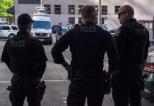 Three police officers standing on a city street.