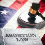 Abortion law book, gavel, and American flag.