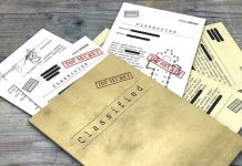 EXPLOSIVE Epstein Files Name College President 2,500 Times Classified documents with Top Secret stamps on wooden surface.