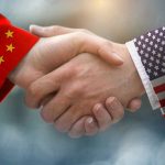 Taiwan Tensions: Trump Puts US-China Ties on Edge Chinese and American flag sleeves shaking hands.