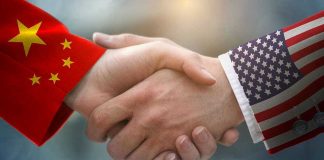 Taiwan Tensions: Trump Puts US-China Ties on Edge Chinese and American flag sleeves shaking hands.