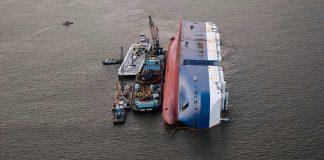 Shock Attack: Odesa in Flames! Capsized ship with cranes and tugboats around it.