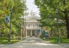 Artists Bolt, Trump Escalates Culture War Historic stone building surrounded by trees and lampposts.