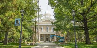 Artists Bolt, Trump Escalates Culture War Historic stone building surrounded by trees and lampposts.