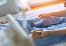 Seemingly Innocent ‘Stomach Bug’ Lands Teen in Coma Hospital patient holding visitors hand reassuringly.