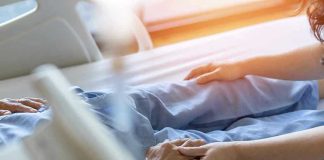 Seemingly Innocent ‘Stomach Bug’ Lands Teen in Coma Hospital patient holding visitors hand reassuringly.