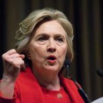 Why Clinton’s Legacy Still Fuels Female President Debate Person speaking passionately at a podium, wearing red jacket.