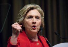 Why Clinton’s Legacy Still Fuels Female President Debate Person speaking passionately at a podium, wearing red jacket.