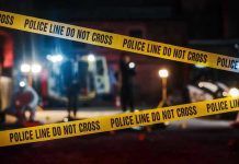 Festival Chaos: Gunman Still Loose Yellow police tape in front of crime scene.