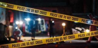 Festival Chaos: Gunman Still Loose Yellow police tape in front of crime scene.