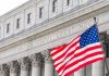 DOJ Nails VOA Worker After 15 Months United States courthouse with American flag waving.
