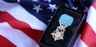 Trump Revives Forgotten Hero A military medal displayed on a black box with an American flag background