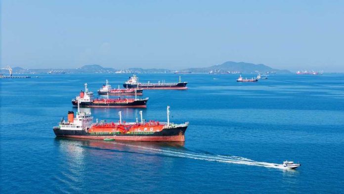 shutterstock_2755727965 Several cargo ships navigating in a calm ocean