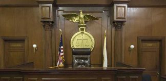 Six Months For Child Rape?! Judges bench in an empty courtroom, scales emblem above.