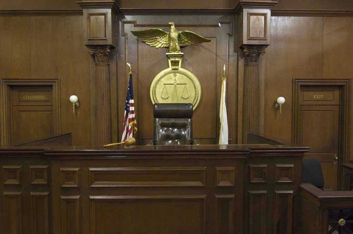 121502698 Judges bench in an empty courtroom, scales emblem above.