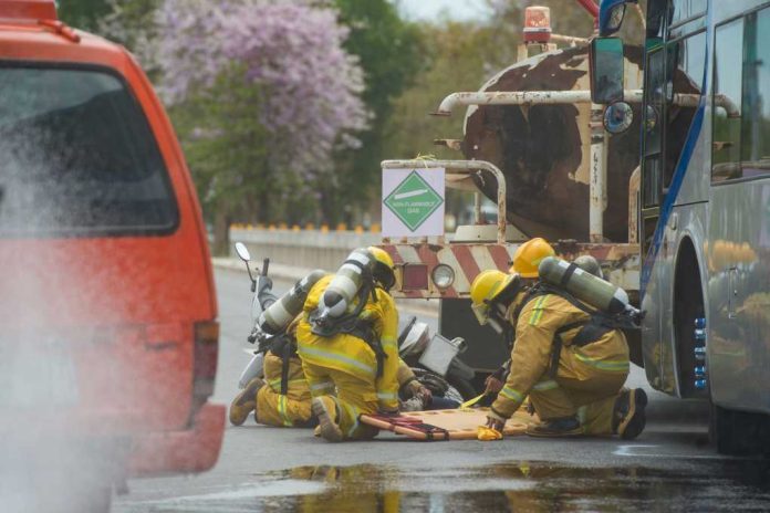shutterstock611990597jpg Firefighters assist crash victim between a tanker and bus on a road