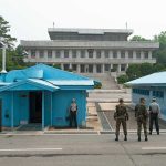 Trump Claims Total Hamas Disarmament Deal Military personnel standing near blue buildings at a border crossing