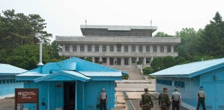 Trump Claims Total Hamas Disarmament Deal Military personnel standing near blue buildings at a border crossing