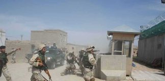Iranian Missiles Kill Americans Soldiers in desert uniforms run past a checkpoint amid dust
