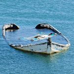 partially sunken boat in calm blue water