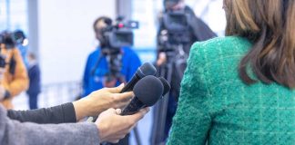 ESPN’s Double Standard Exposed Hands holding microphones in front of a person at a press conference