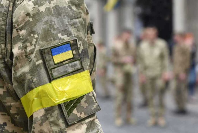 shutterstock_2166899897 Soldier in camouflage with Ukrainian flag patch and yellow armband