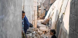 Power Shields Predators In Afghanistan children in a narrow alley with rubble