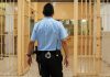 50 Police Chiefs Unite Against Early Release of Criminals corrections officer walking through prison corridor