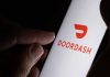 Restaurant Data Demand Gets Torched By Courts Hand holding smartphone showing DoorDash app logo