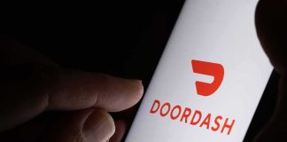 Restaurant Data Demand Gets Torched By Courts Hand holding smartphone showing DoorDash app logo