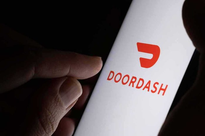 shutterstock_1637408869 Hand holding smartphone showing DoorDash app logo
