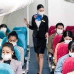 American Airlines Drops $1,000 Surprise Airline passengers wearing masks seated on a flight