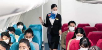 Airline passengers wearing masks seated on a flight