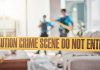 Roommate Arrested After Chilling Find crime scene tape in a living room with two officers in background