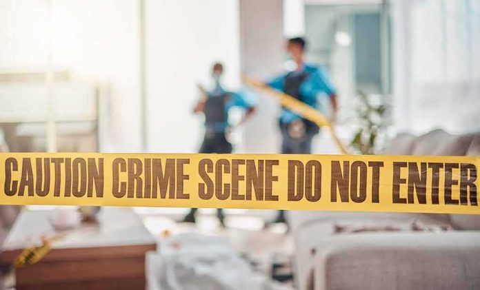 shutterstock_2329488061 crime scene tape in a living room with two officers in background