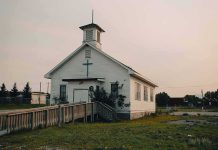 Church Turned Kill Zone — Dozens Vanish Small white church with steeple and cross at sunset
