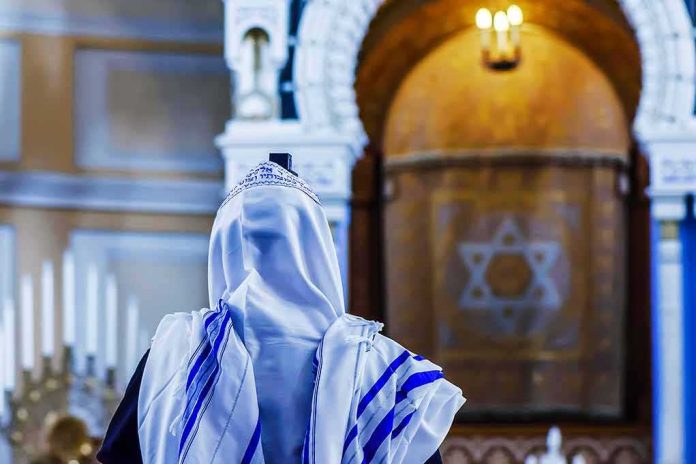 Person in white and blue prayer shawl facing ornate interior