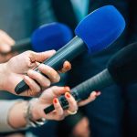 See What Trump Said About the Clancy Case Reporters holding colorful microphones