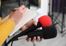 Iran Threatens South Korean If It Joins Hormuz Mission Journalist holding two microphones while writing in a notebook