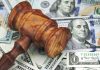 Dems GRILL Bessent Over Trump’s $5,000 Dividend Wooden judge's gavel on scattered US dollar bills
