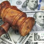 Dems GRILL Bessent Over Trump’s $5,000 Dividend Wooden judge's gavel on scattered US dollar bills