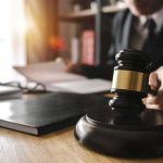 Shocking Conviction Over Kid’s Short Walk Judge's gavel on desk with person reading documents in background
