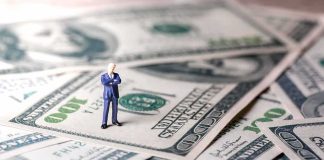 Country Just Assigned Billionaires Their Own Tax Watchers Miniature businessman standing on US dollar bills