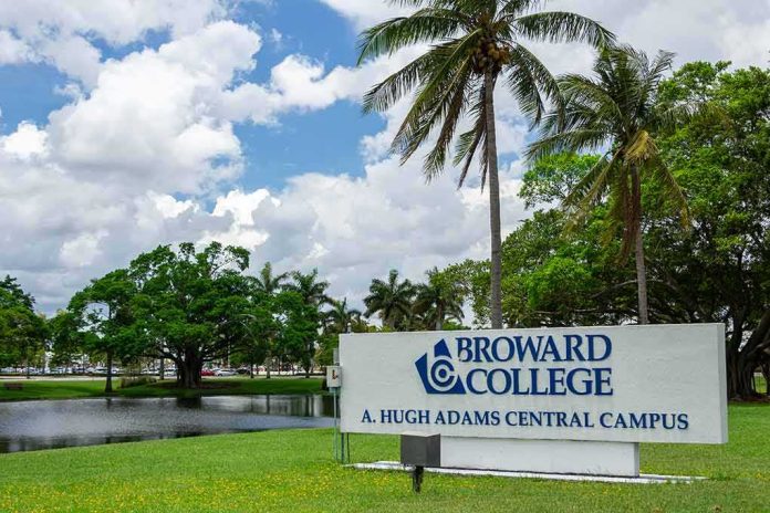 Broward College campus sign by palm trees and pond