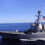 Trump Threatens Military Action Against US Ally Naval destroyer sailing on open sea with flag flying