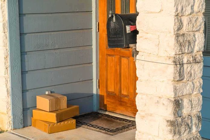 shutterstock_1159659994 Packages stacked on a doorstep by a wooden front door