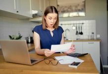 This State Wants to Add ‘JEWISH’ to State Forms Woman in kitchen reacting to a bill at a table with laptop and calculator